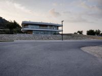 this building is situated on top of a hill next to a paved area where people can walk