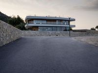 this building is situated on top of a hill next to a paved area where people can walk