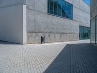 there is a stone wall that reflects the parking area in the window glass at the corner