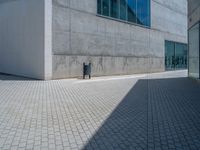 there is a stone wall that reflects the parking area in the window glass at the corner