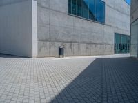 there is a stone wall that reflects the parking area in the window glass at the corner