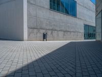 there is a stone wall that reflects the parking area in the window glass at the corner