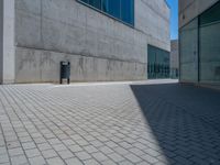 there is a stone wall that reflects the parking area in the window glass at the corner