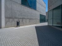 there is a stone wall that reflects the parking area in the window glass at the corner