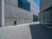 there is a stone wall that reflects the parking area in the window glass at the corner