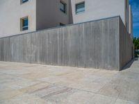 the gray concrete walls of a building have a line of steps on the left side