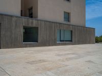 the gray concrete walls of a building have a line of steps on the left side