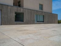 the gray concrete walls of a building have a line of steps on the left side