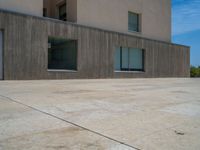 the gray concrete walls of a building have a line of steps on the left side