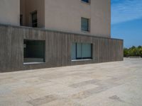 the gray concrete walls of a building have a line of steps on the left side