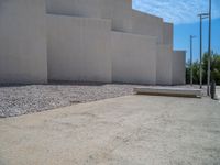 the gray concrete walls of a building have a line of steps on the left side