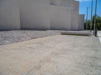 the gray concrete walls of a building have a line of steps on the left side