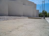 the gray concrete walls of a building have a line of steps on the left side