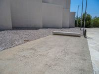 the gray concrete walls of a building have a line of steps on the left side