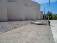 the gray concrete walls of a building have a line of steps on the left side