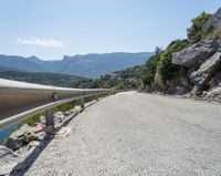 there is a motorcycle that is going up the hill on a curved road, overlooking the water