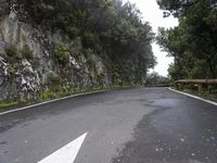 a road goes uphill to the right on a windy day in the mountainside