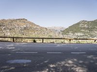 a empty road with mountains and trees in the background for a photo of a bicycle