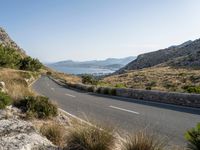 the open road stretches across the mountains past a body of water, which is partially submerged by hills