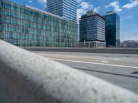 a group of tall buildings sit next to a street in the city where the road runs alongside