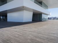 wooden floors in an empty outdoor area, with large windows to the side and a sky view of the city