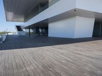 wooden floors in an empty outdoor area, with large windows to the side and a sky view of the city