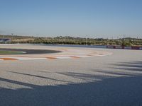 the green road and orange and white stripe line at an event near the racetrack and stadium