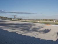 the green road and orange and white stripe line at an event near the racetrack and stadium