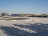 the green road and orange and white stripe line at an event near the racetrack and stadium