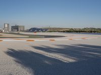 the green road and orange and white stripe line at an event near the racetrack and stadium