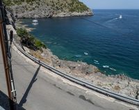 a paved road beside some large boats and a bridge with a bridge to the water