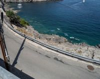 a paved road beside some large boats and a bridge with a bridge to the water