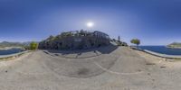 a 360 - view of people skating in the mountains around water and mountains, with a sun