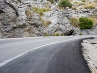 a lone bike is on the side of a mountain road, just beyond it,