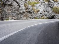 a lone bike is on the side of a mountain road, just beyond it,