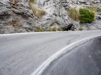 a lone bike is on the side of a mountain road, just beyond it,