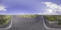 the image is taken from a fish eye lens as a car drives on a road