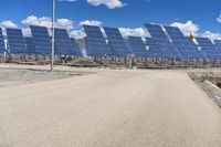 a parking lot with several rows of solar panels and an empty area in the background