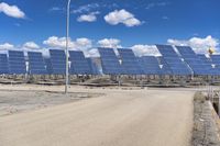 a parking lot with several rows of solar panels and an empty area in the background