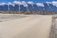 a parking lot with several rows of solar panels and an empty area in the background