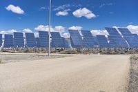 a parking lot with several rows of solar panels and an empty area in the background