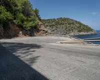 a paved road beside some large boats and a bridge with a bridge to the water