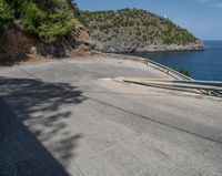 a paved road beside some large boats and a bridge with a bridge to the water