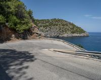 a paved road beside some large boats and a bridge with a bridge to the water