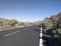 a empty road going in between two mountains on a clear day or no clouds in the sky