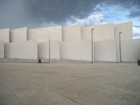 empty area outside concrete building with no people or vehicles at the entrance to area behind it