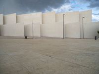 empty area outside concrete building with no people or vehicles at the entrance to area behind it