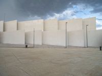 empty area outside concrete building with no people or vehicles at the entrance to area behind it