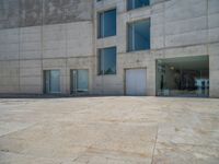 the gray concrete walls of a building have a line of steps on the left side