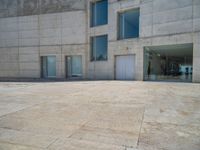 the gray concrete walls of a building have a line of steps on the left side